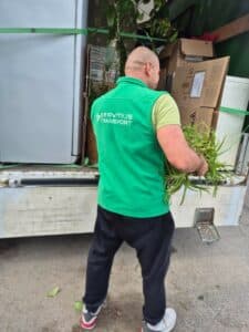 Servitius Transport munkatárs óvatosan pakol növényeket és dobozokat a költöztető teherautóba.